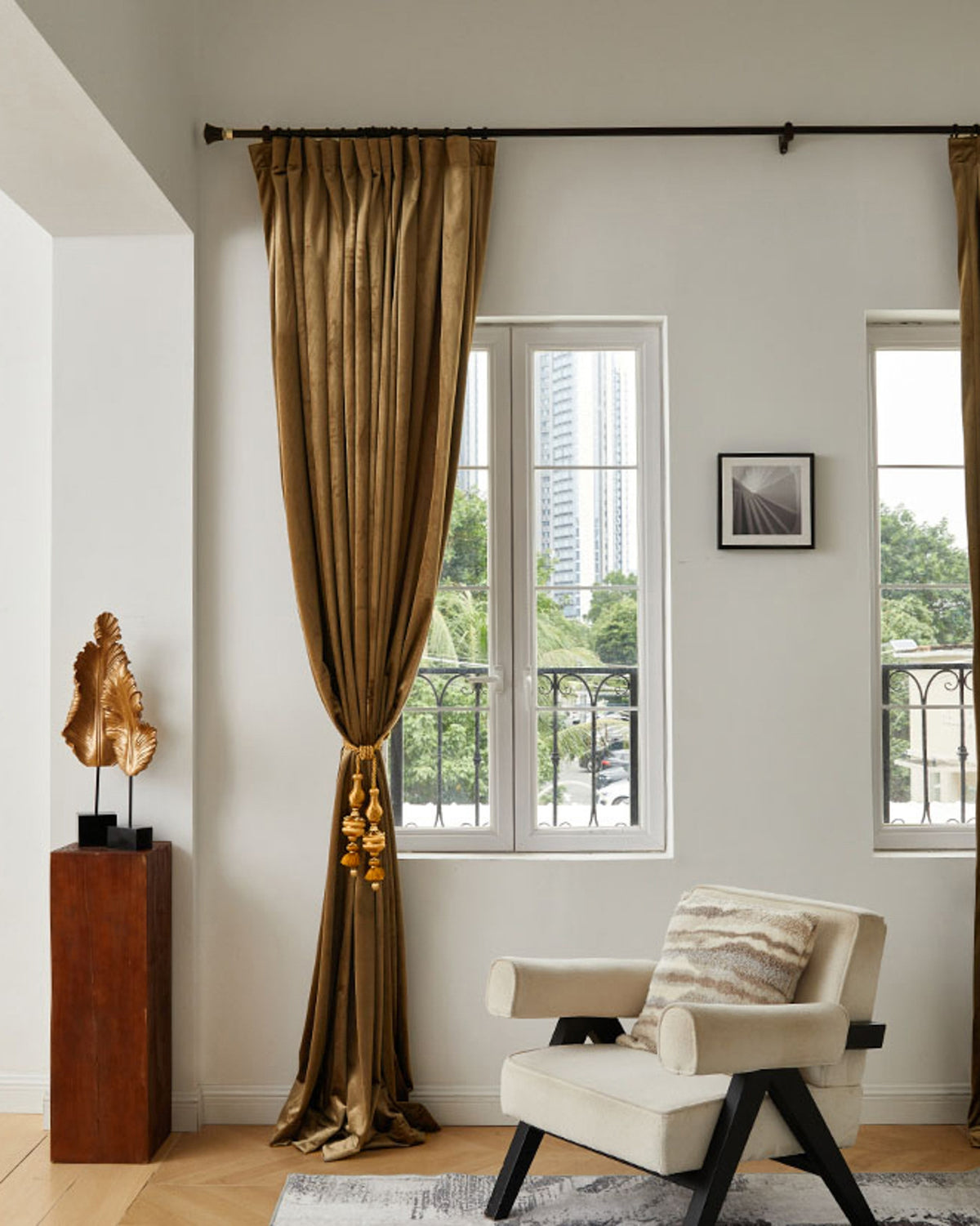 Made-to-measure Moonlit Velvet custom curtain in a sophisticated living room, tied back with gold tassels for balanced light & privacy.