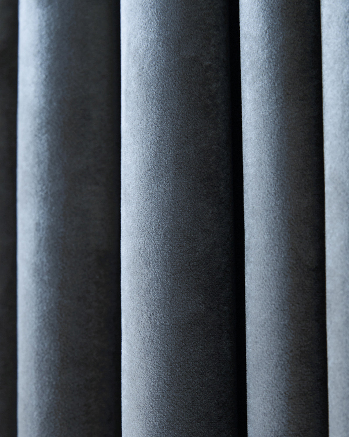 Close-up of luxurious Moonlit Velvet custom curtain showing soft texture and elegant vertical pleats in dark grey.