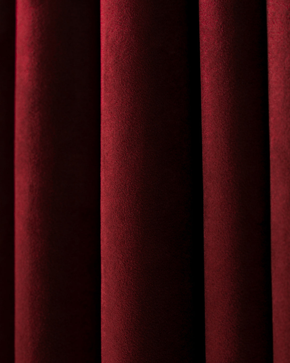 Textured close-up of Moonlit Velvet custom curtains in deep red, showcasing the opulent fabric and soft pleats for elegant window treatments.