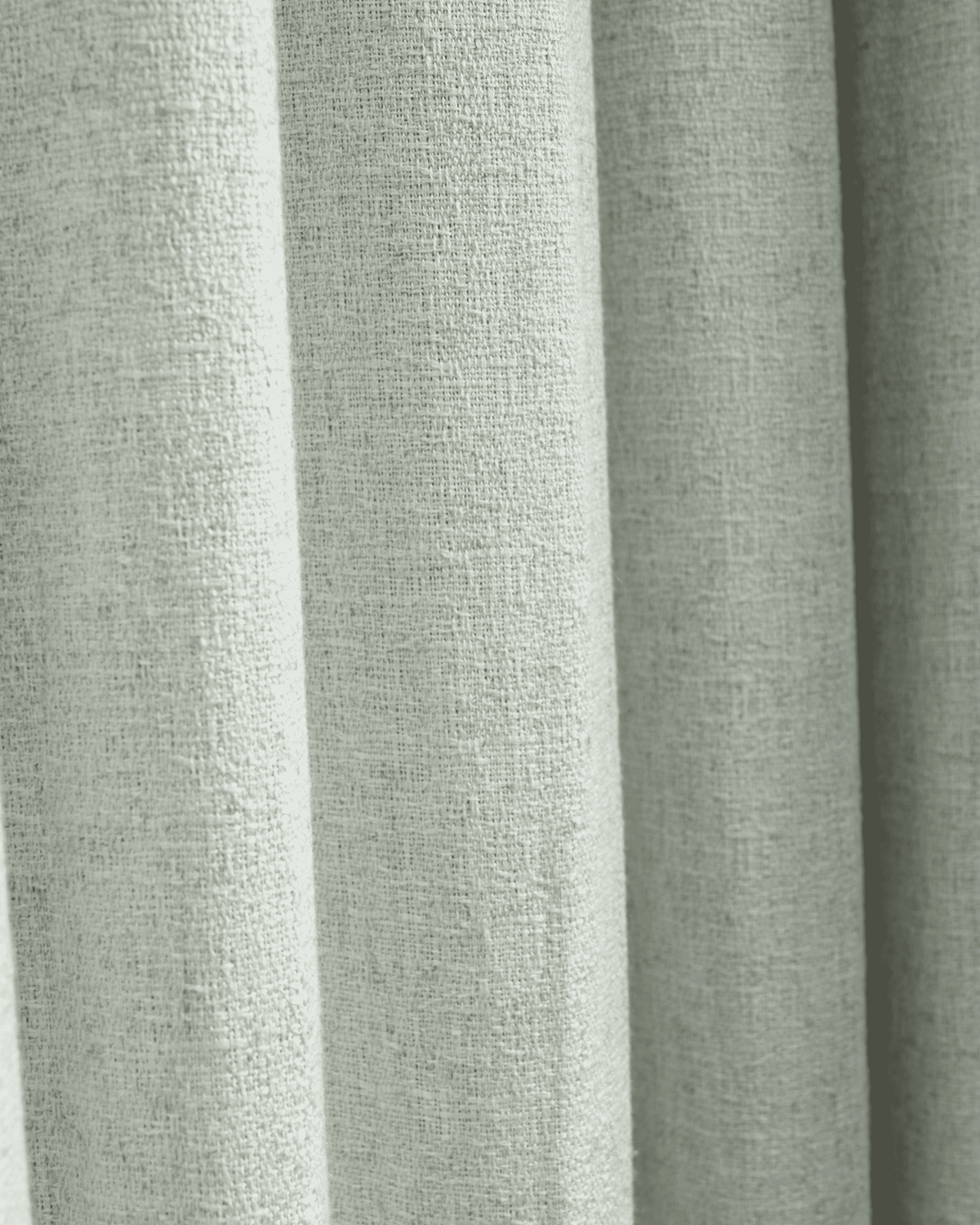 Close-up of Fiona linen blend custom curtain fabric in sage green, highlighting its textured weave and soft folds.
