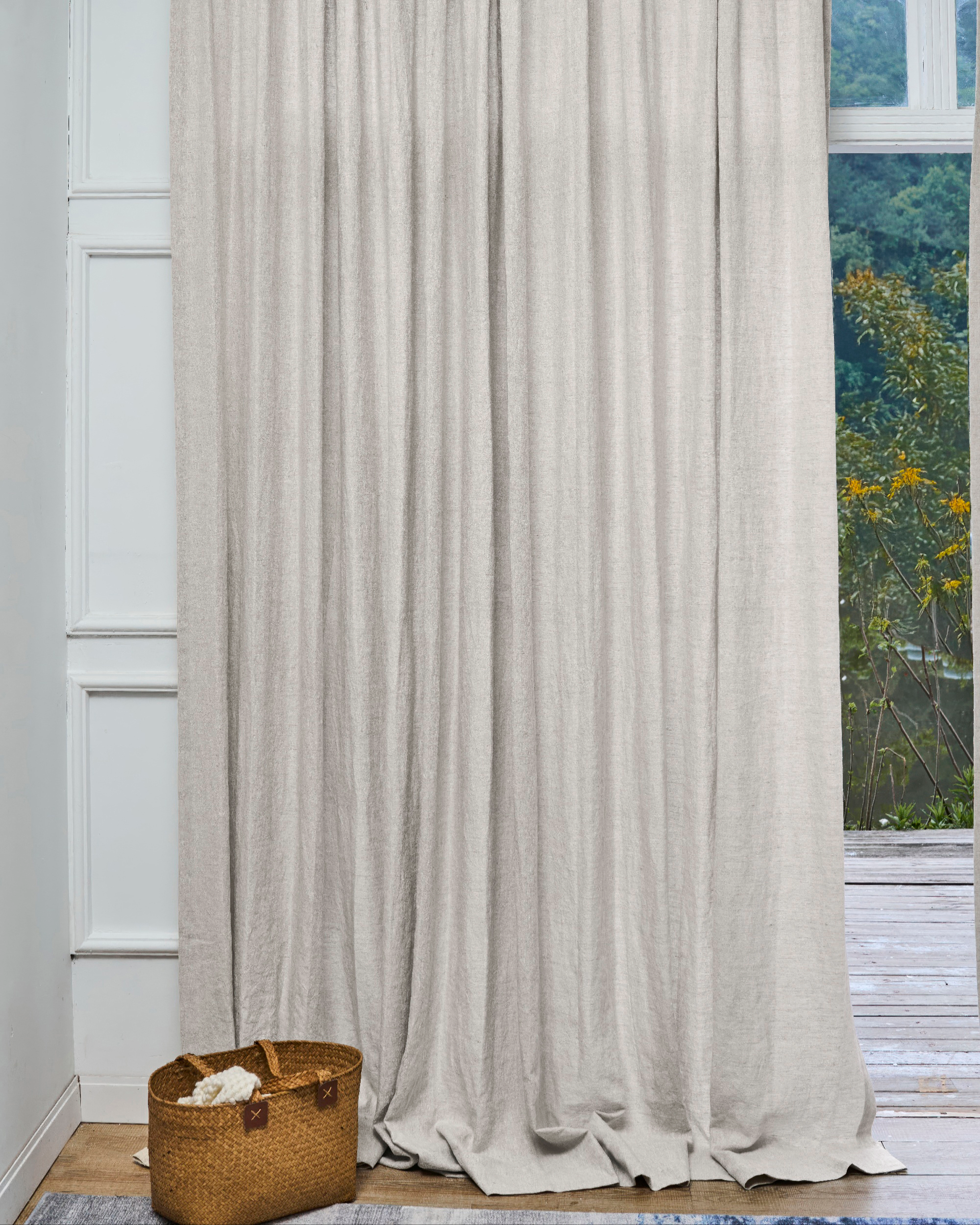 Tahiti pure linen custom drapery in light beige, artfully draped for sophisticated home aesthetics & gentle light control by a window.