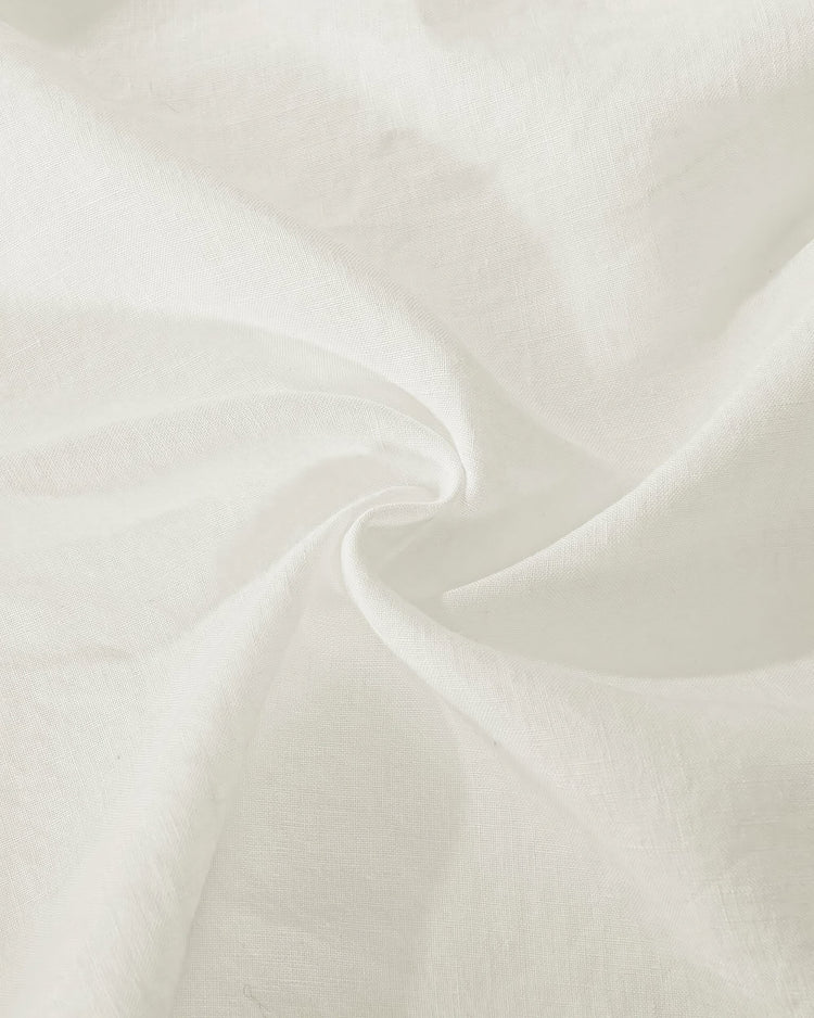 Close-up of soft white Kyoto 100% linen semi-sheer custom curtain fabric, highlighting its delicate weave and graceful drape.