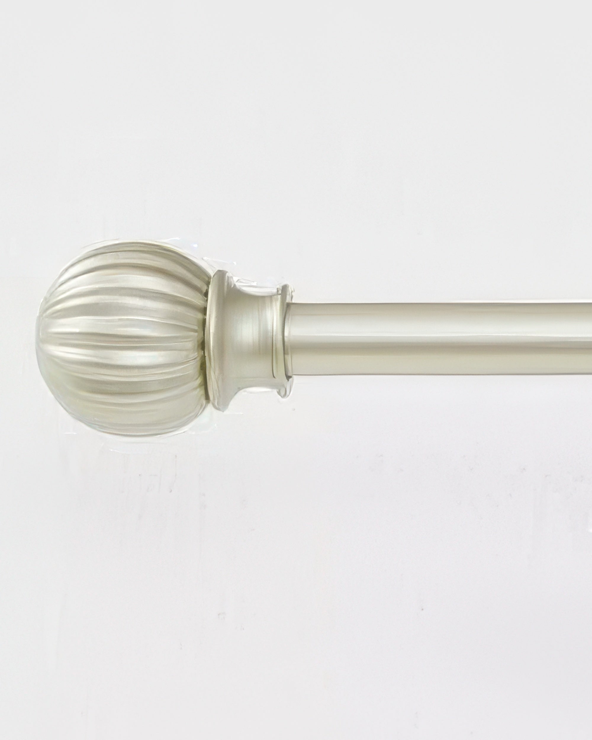 Detailed view of a brass adjustable curtain rod with a decorative ribbed finial for luxury window treatments.