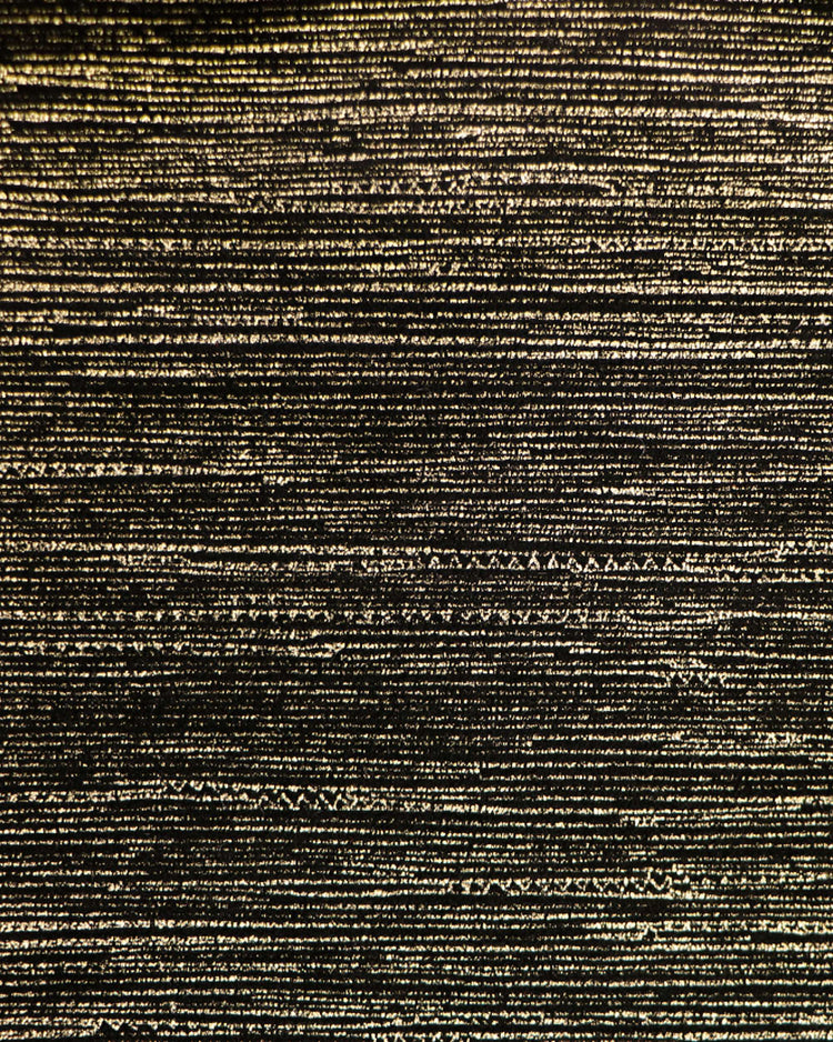 Close-up of luxurious foil printed black velvet blackout curtain fabric featuring shimmering horizontal golden textured lines.
