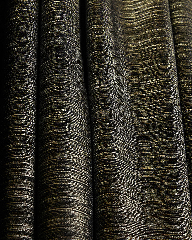Black velvet custom curtain with intricate gold foil horizontal print, highlighting the luxurious texture and elegant drape.