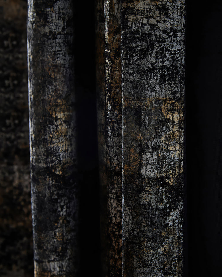 Close-up of luxurious custom velvet drapery, featuring a dark Impression foil printed pattern with shimmering metallic gold and silver details.