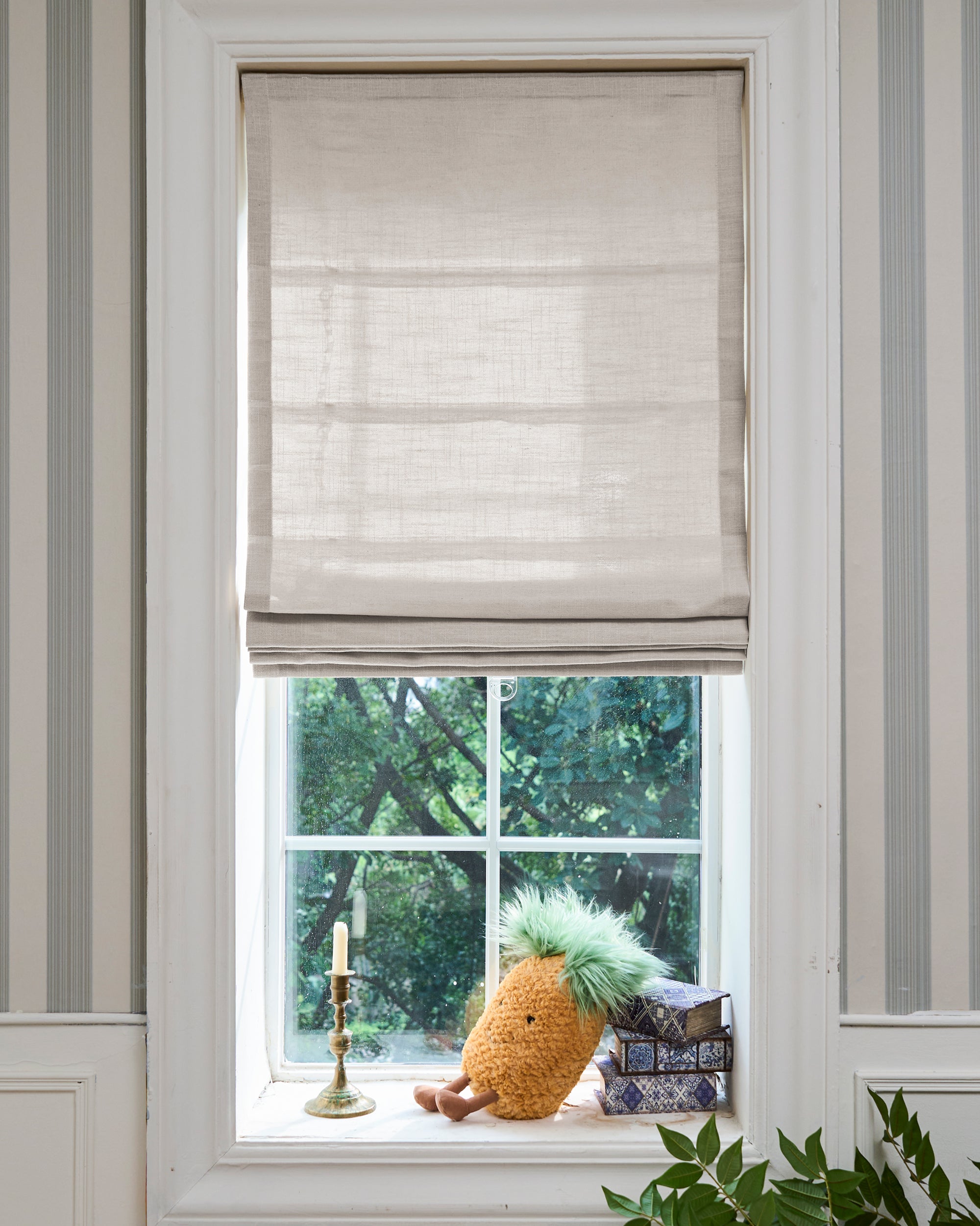 Elegant Cassie Flat Fold Linen Blend Custom Roman Shade in a window, showcasing its crisp folds and textured fabric for sophisticated light control.