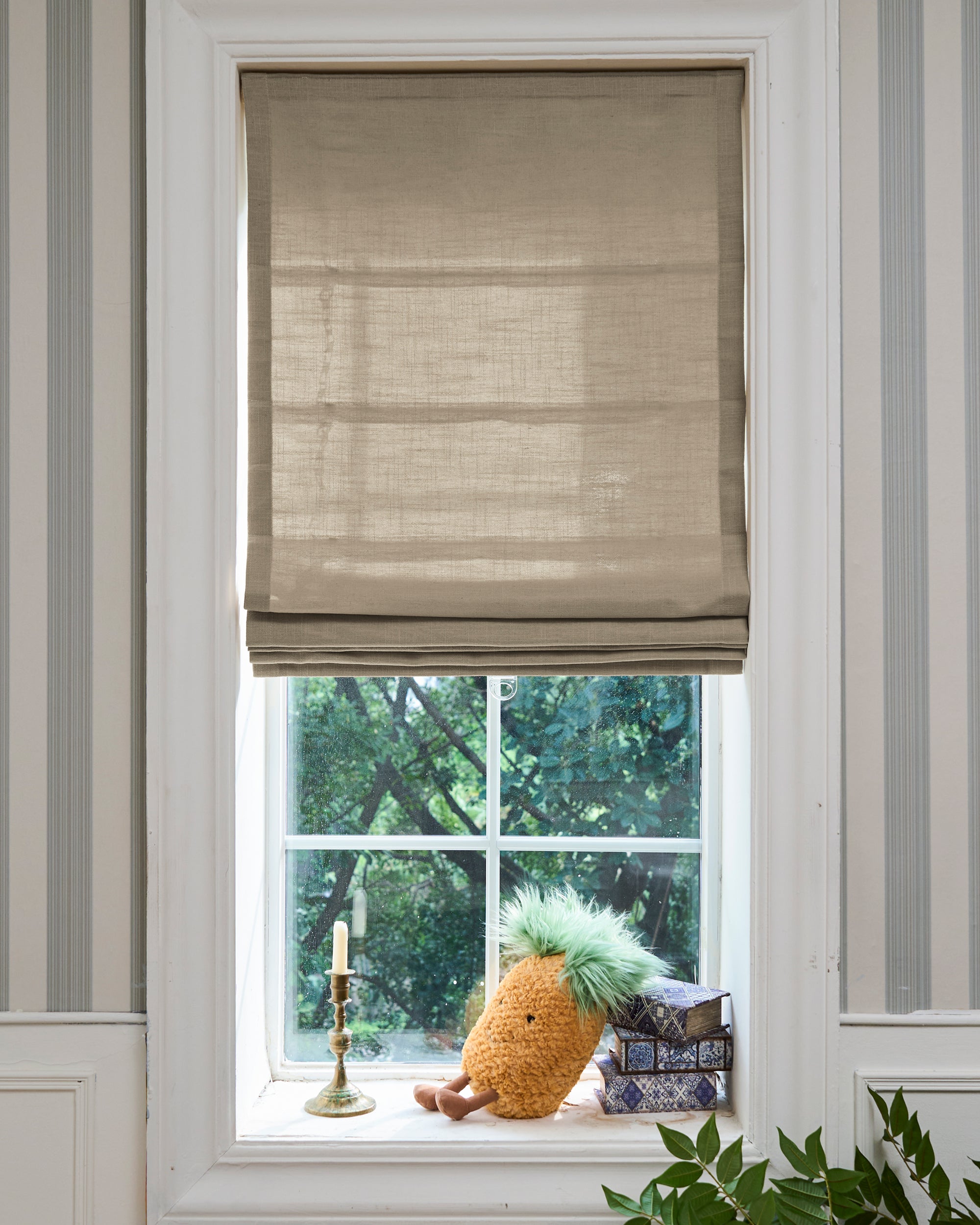 Custom natural linen-blend Cassie Flat Fold Roman Shade on a window, highlighting its textured fabric and crisp folds for tailored light control.