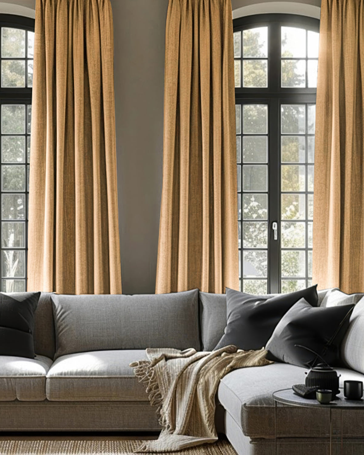 Cronin Linen Look Blackout Custom Curtains in warm golden-brown, styled on arched windows in a sophisticated living room with a gray sofa.