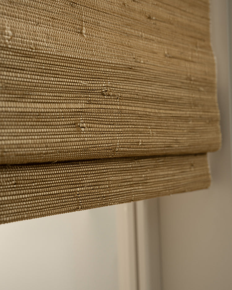 Sand Mia Jute Woven Shade detail, showcasing the natural fiber texture, tight weave, and subtle folds of this custom window treatment.
