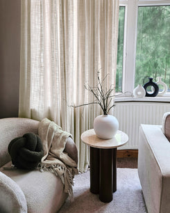 Jupiter Linen Look Soft Heavyweight Sheer Custom Curtains filtering sunlight in a sophisticated living room with an armchair.