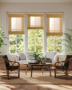 Three custom Toni Bamboo Woven Shades with natural light filtering texture on large windows, creating a serene, bright living room.