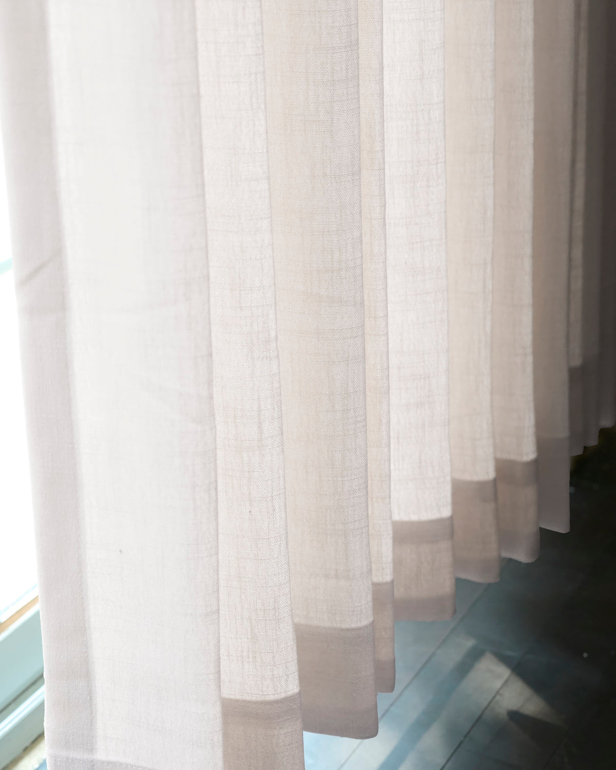 Textured sheer Cassie Linen Blend custom curtains letting soft light through, creating elegant shadows on the floor.