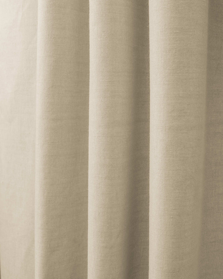 Close-up of Cronin linen look blackout custom curtain fabric in a natural beige, showing textured weave and soft folds.