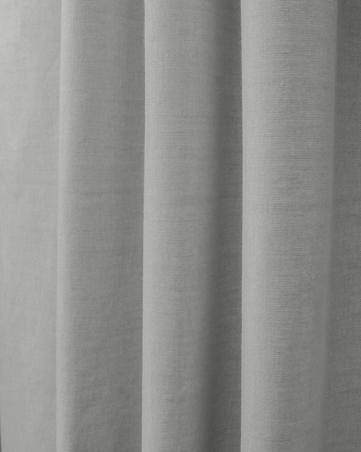 Grey Cronin linen look blackout custom curtain fabric showing its weave texture and soft vertical folds.
