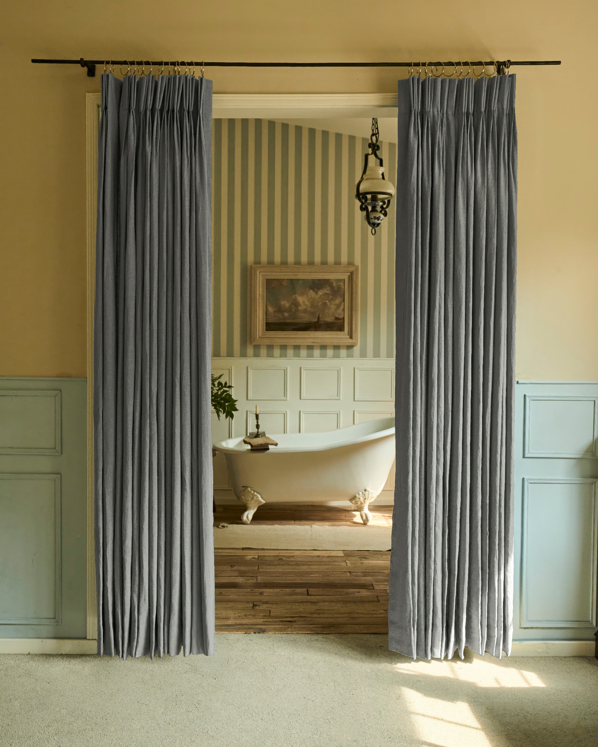 Elegant dark grey linen custom curtains with refined pinch pleats on a black rod, providing luxurious custom window treatments.