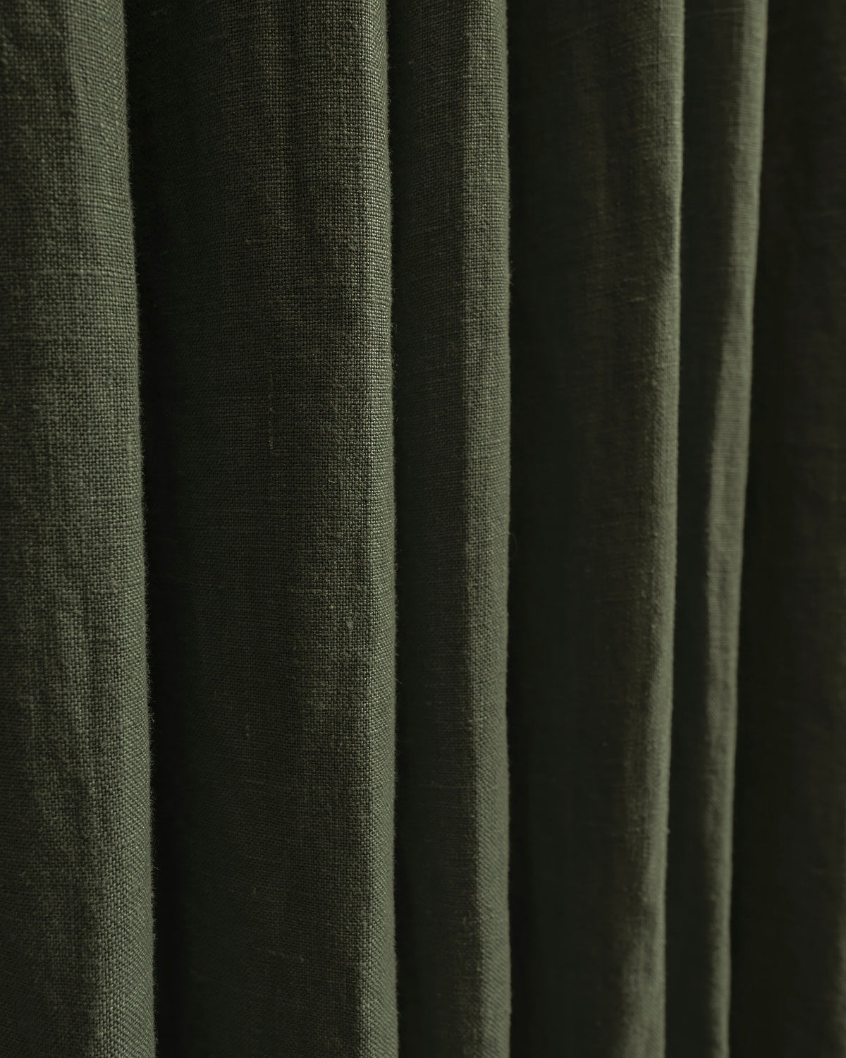 Rich dark green Helena custom pure linen curtain, displaying textured weave, luxurious fabric, and soft, tailored folds.