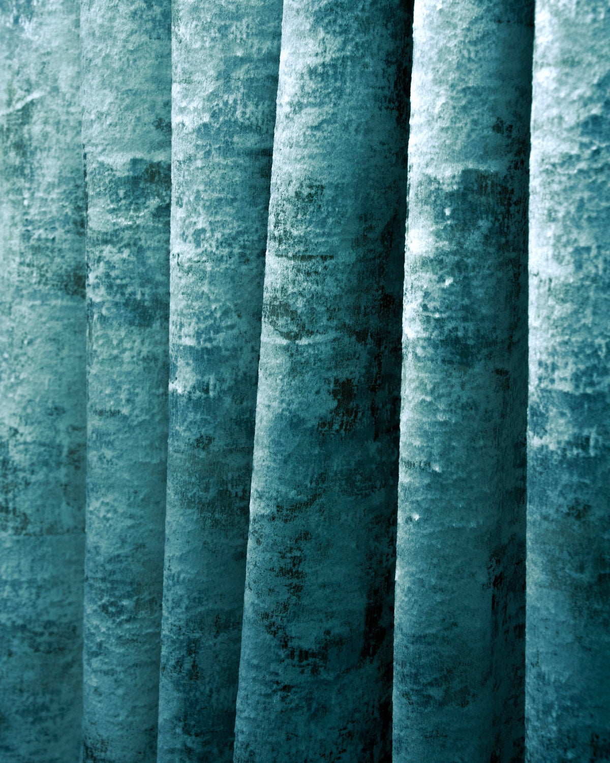 Close-up of richly draped teal Impression Foil Printed Velvet custom curtain, showcasing its abstract foil-printed pattern.