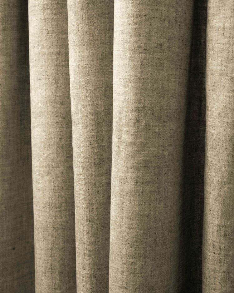 Detailed natural beige custom heavyweight drapery, highlighting the linen-patterned velvet fabric's rich texture and elegant folds.