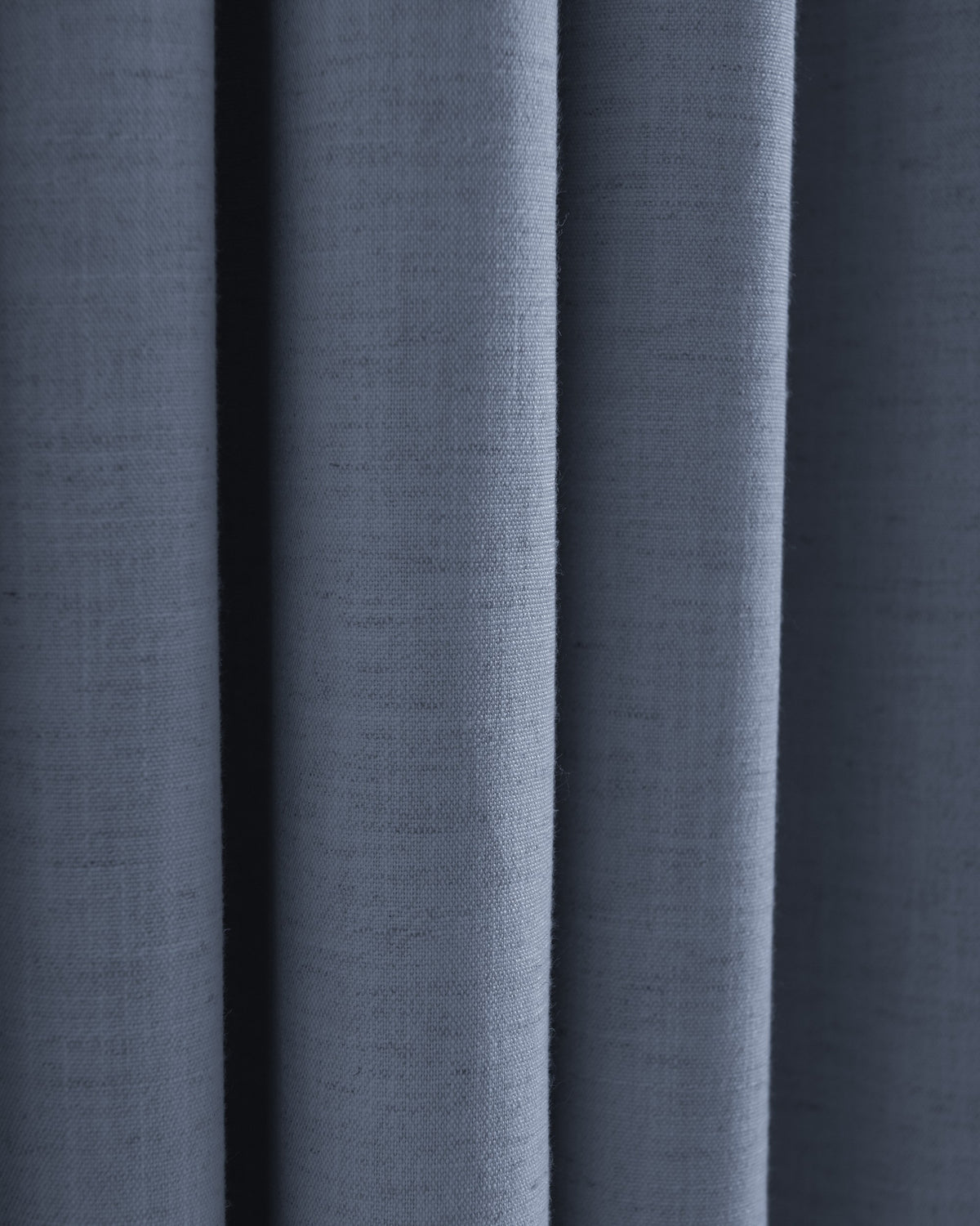 Close-up of dusty blue Sally linen blend fabric texture with soft folds, perfect for custom drapery swatches.