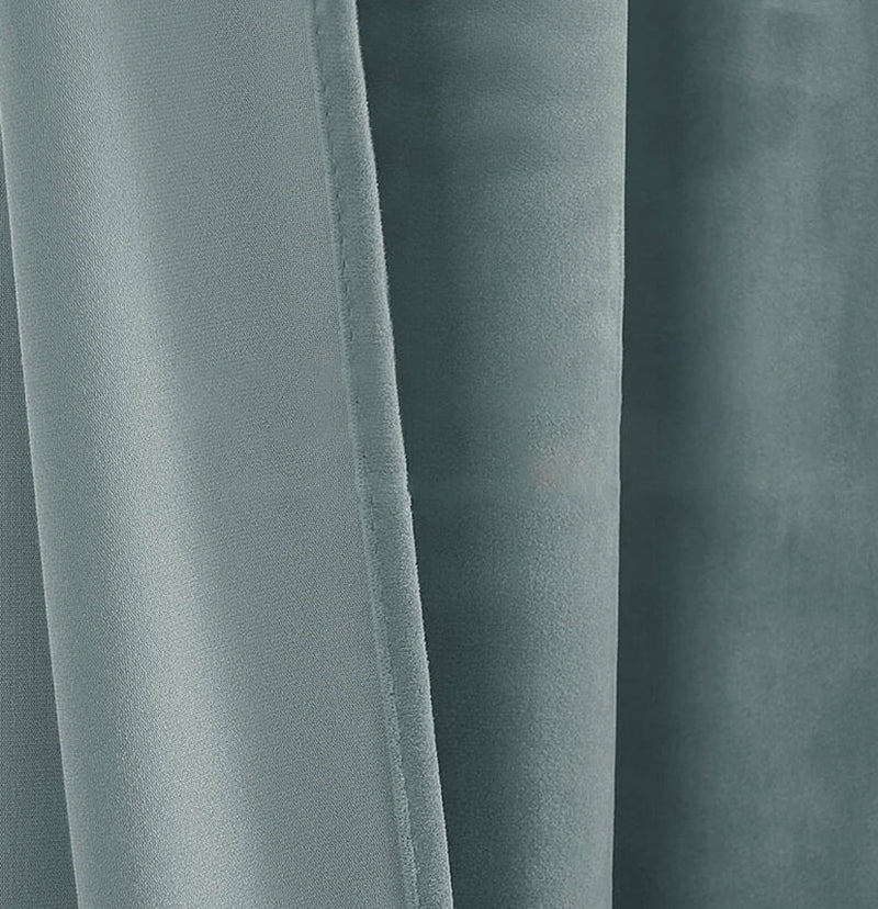 Close-up of plush teal velvet custom curtain fabric, revealing soft folds, rich texture, and elegant drape for luxury window treatments.