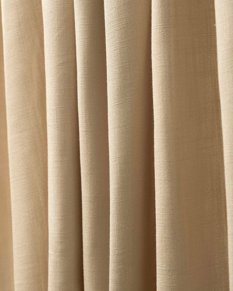Textured Voy 100% blackout custom curtain fabric in a natural beige linen-look, highlighting its premium weave and soft drapery.