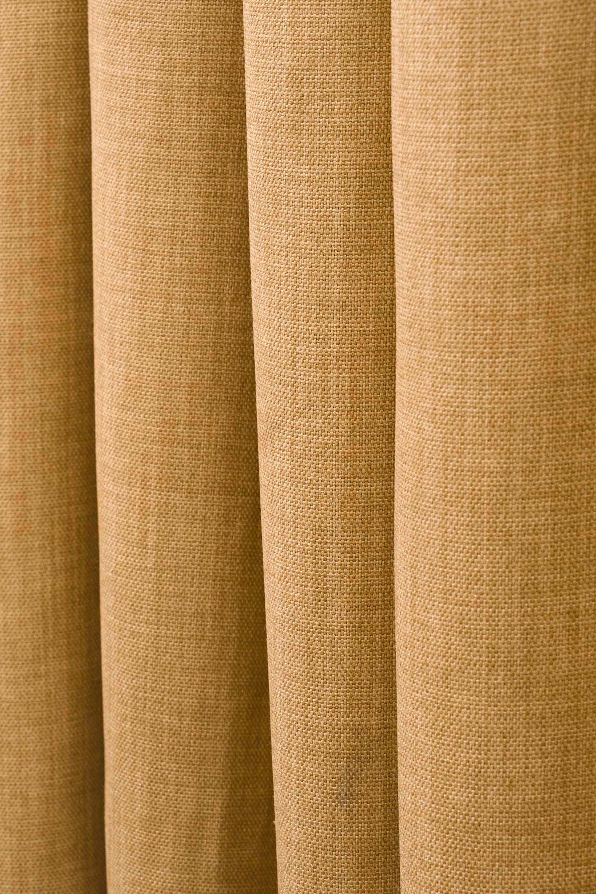 Close-up of Zoe custom linen-look curtain fabric in warm tan, highlighting soft vertical folds and detailed, woven texture for privacy.