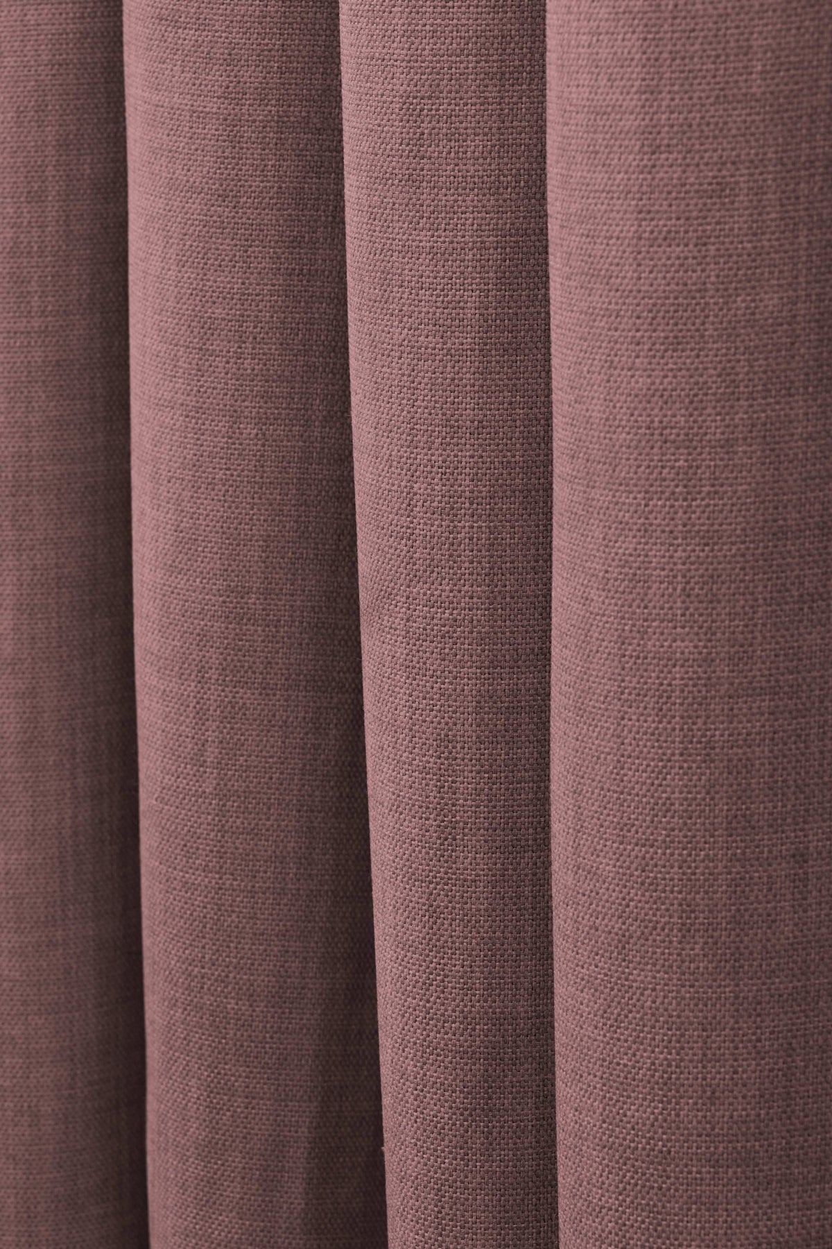 Close-up of Zoe linen-look custom curtain fabric in a dusty rose color, showing soft folds and visible weave texture.