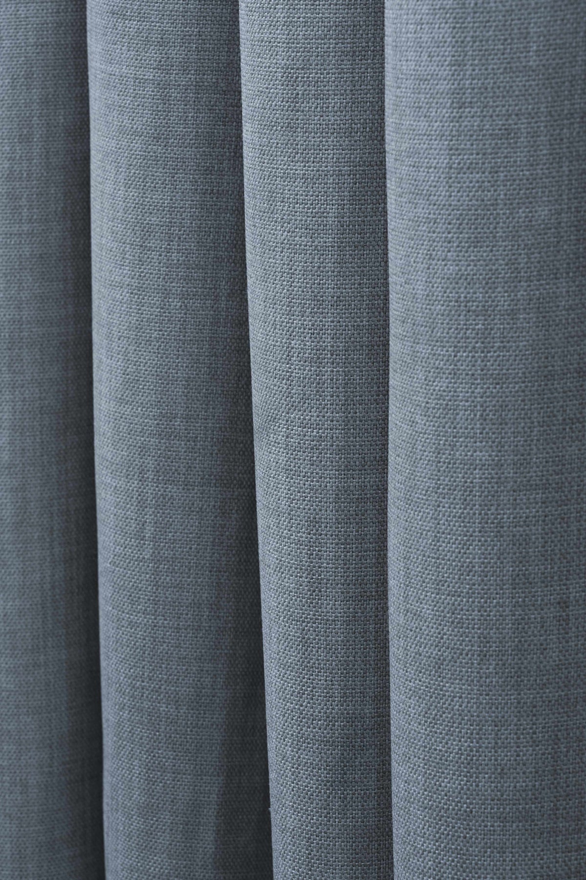 Close-up of a slate blue Zoe linen look custom curtain, highlighting its soft, textured fabric and elegant drapery folds.