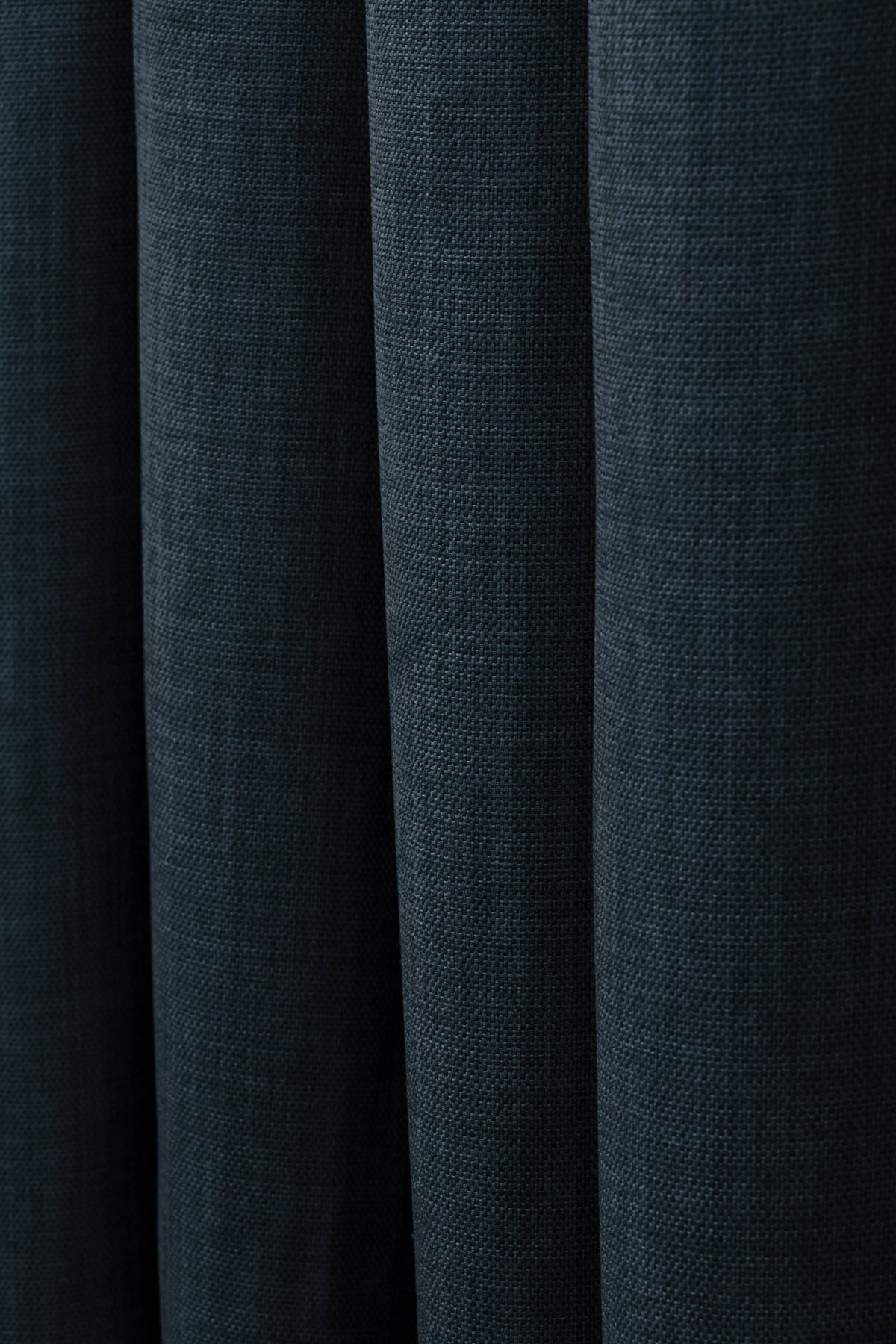Deep navy blue custom linen look curtain fabric with soft, elegant folds, highlighting premium texture for home decor.