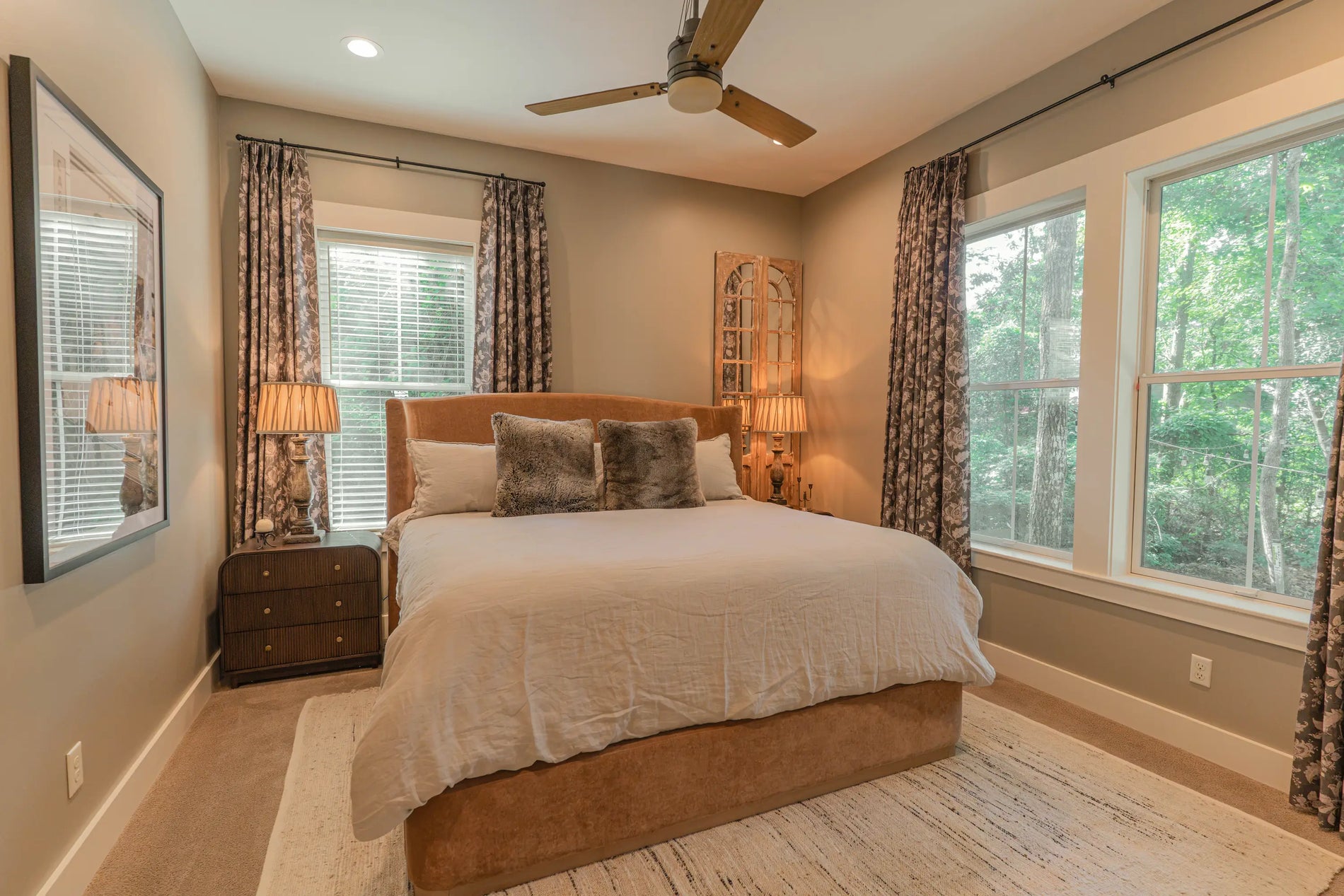 Primary bedroom at Guilford Cottage with patterned floor-length curtains framing two windows
