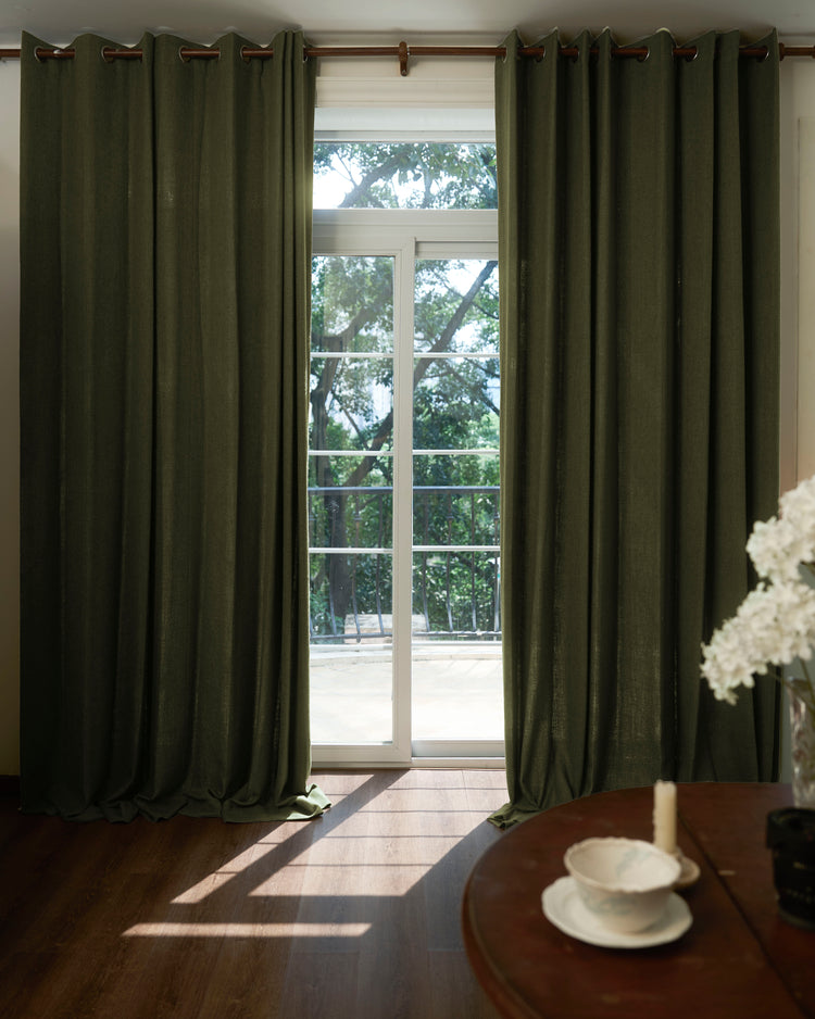 Iris Textured Custom Curtains: floor-length dark olive drapery with tactile grid texture, grommet header, framing a sunlit window.