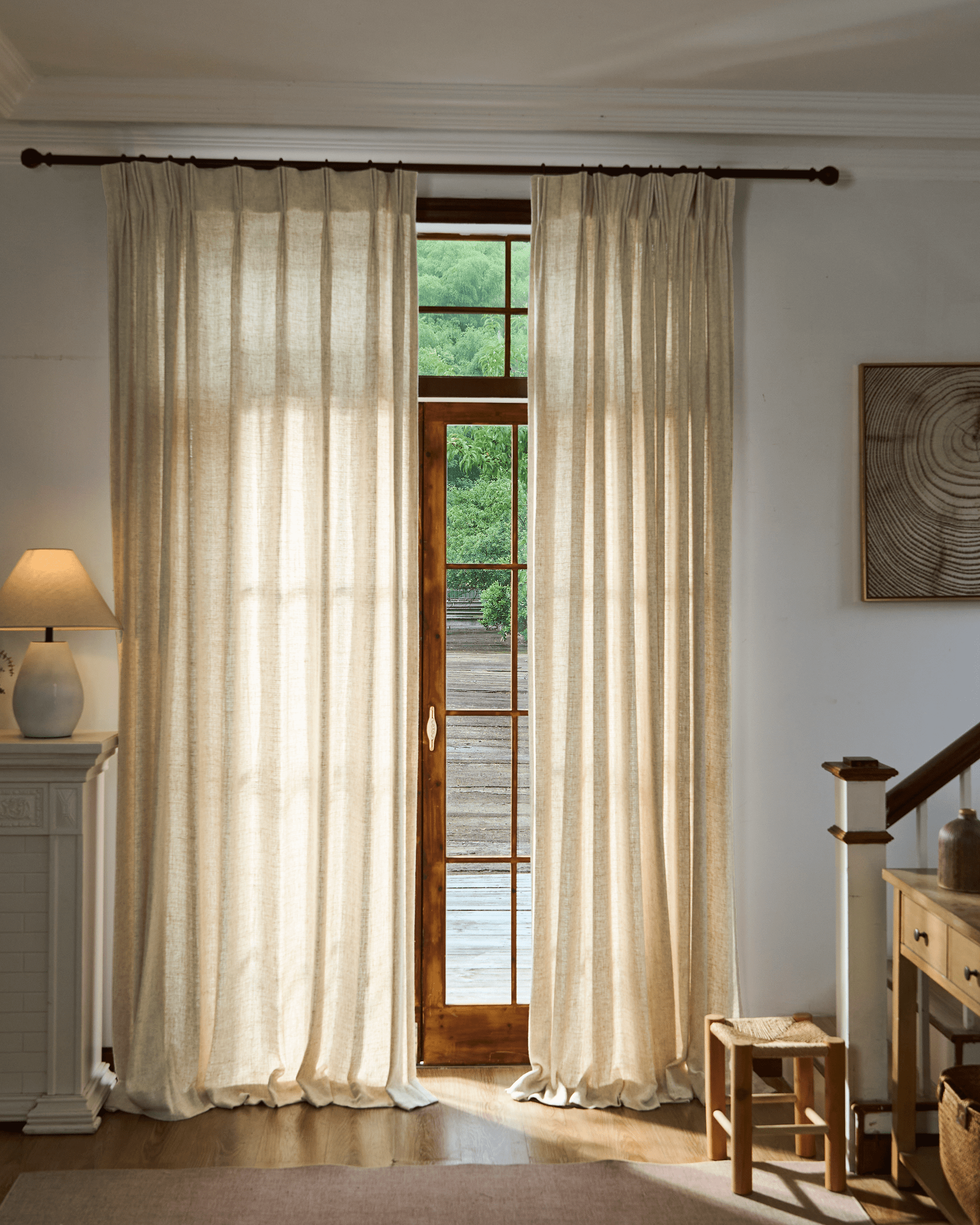 Elegant Fiona custom linen blend curtains in natural tone, tailored to frame a wooden door, providing balanced light and privacy.