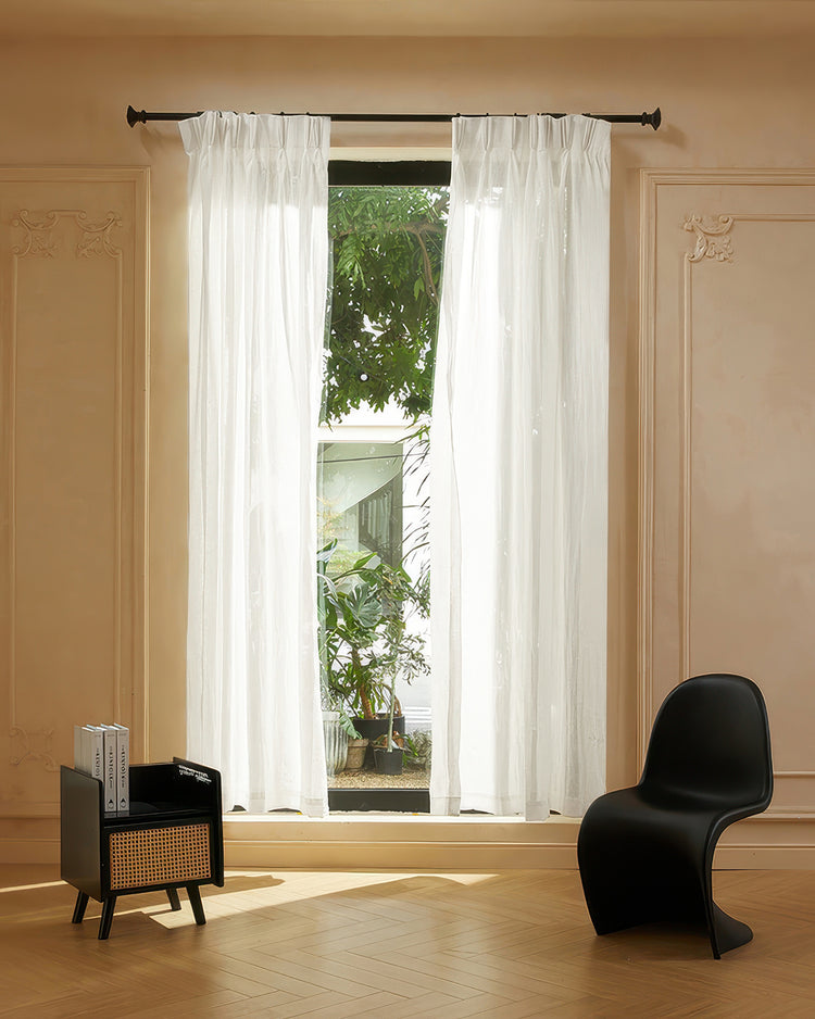 Unwind linen blend grid-like woven sheer custom curtains, pleated, on a dark rod, filtering light in a modern home.