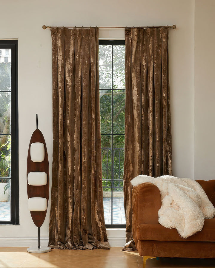 Casablanca custom foil printed velvet window treatments in shimmering brown, elegant pattern, styled in a modern room.