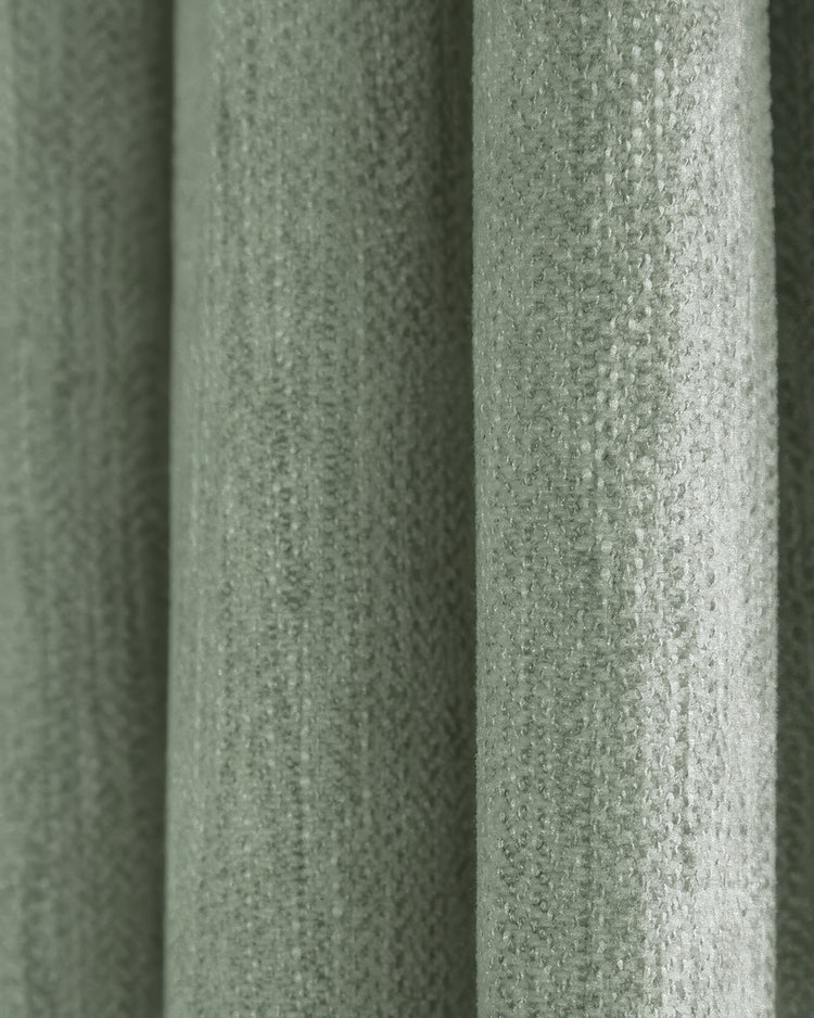 Macro view of Ivy green linen look custom curtain fabric, highlighting its heavyweight, textured herringbone weave.