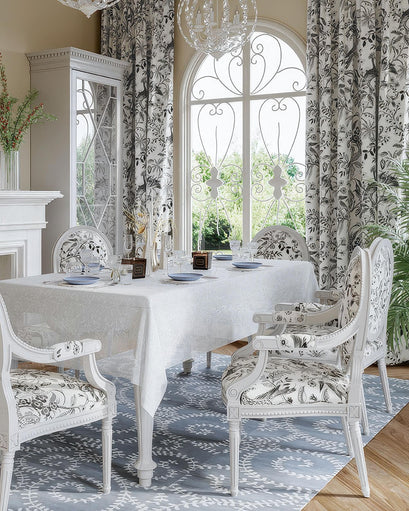 Detailed view of custom Peacock Linen Blend heavyweight floral patterned curtains, matching chairs & white linen tablecloth in an elegant dining room.