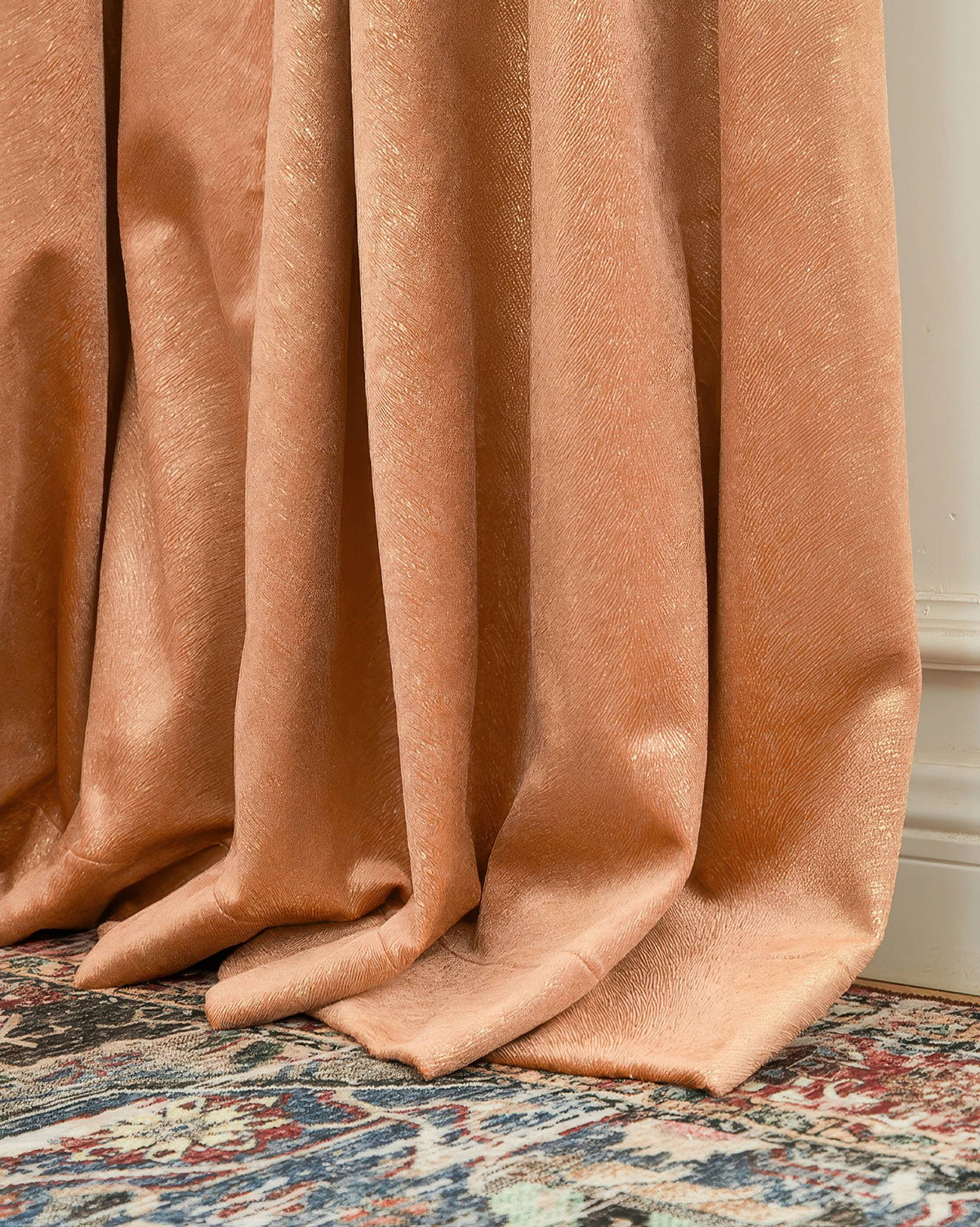 Detailed view of a luxurious peach Palma Foil Printed Velvet Custom Curtain, highlighting its textured shimmering pattern and soft drape on the floor.