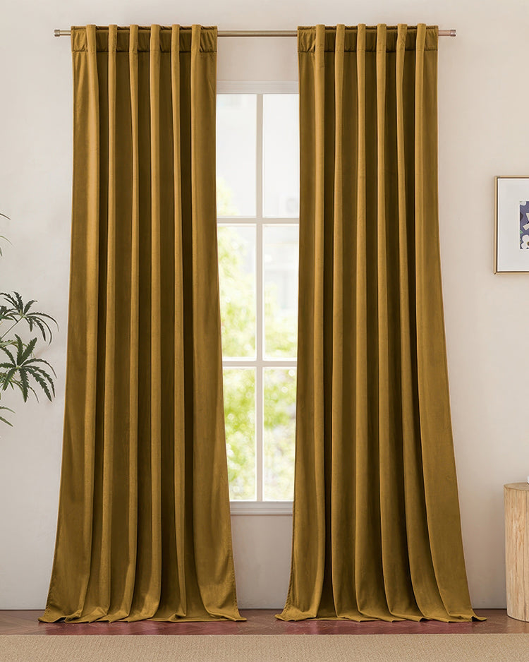 Jazlynn luxurious golden velvet heavyweight custom curtains with back tab header on a rod, perfectly framing a bright window.