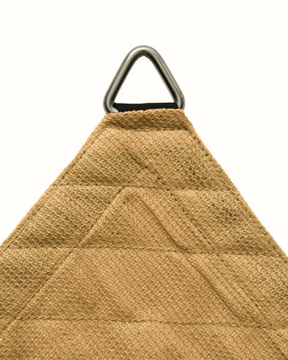 Close-up of a tan HDPE breathable sun shade sail corner with reinforced stitching, black webbing, and a durable metal D-ring.