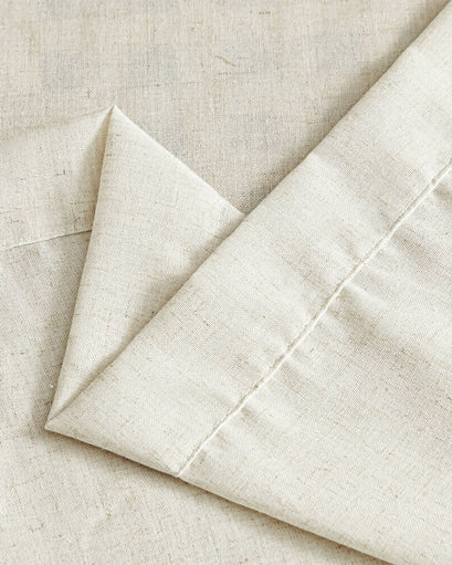 Creamy linen look waterproof custom outdoor curtain fabric. Detailed texture, natural flecks, and crisp folds highlighted.