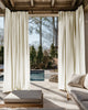 Lightweight Noah Linen Look custom outdoor curtains draping elegantly on a patio pergola, with a pool and outdoor lounge visible.