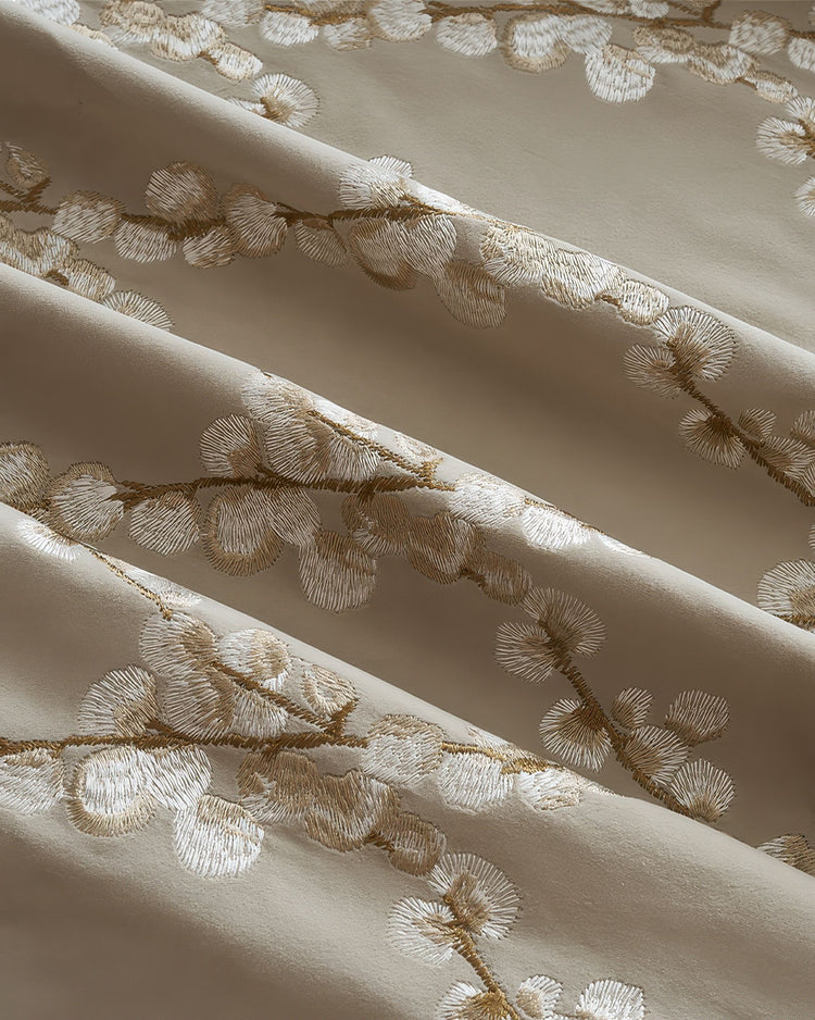 Close-up of Flora Velvet custom curtain fabric with intricate gold embroidered floral pattern, showing soft folds and luxurious texture.