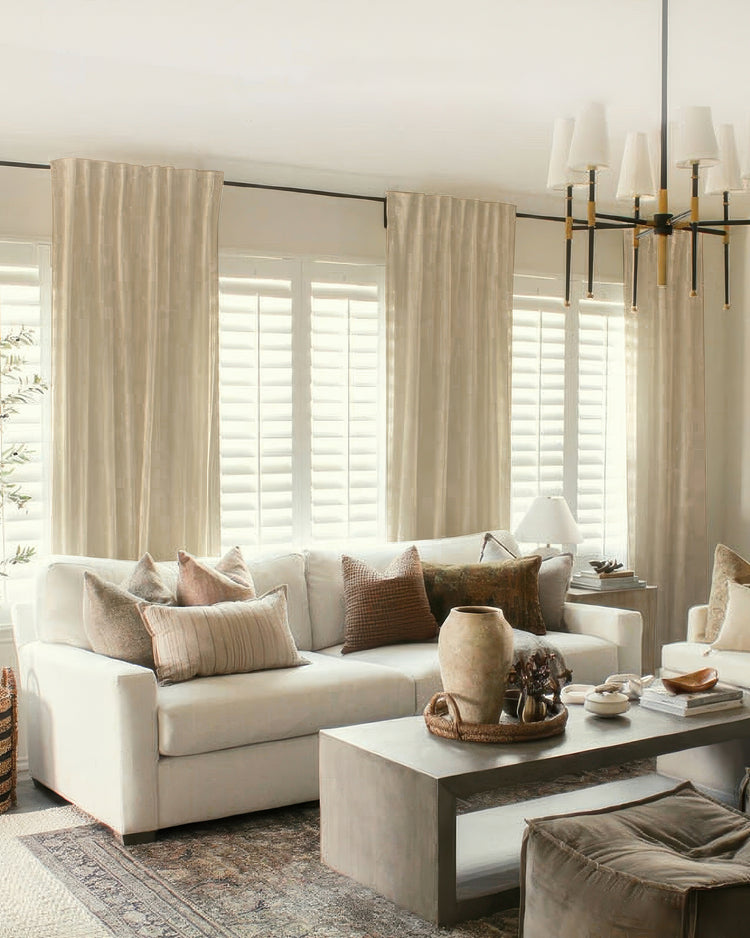 Floor-to-ceiling custom Nara linen & cotton blend lightweight drapery in a sunlit living room with white shutters and neutral decor.
