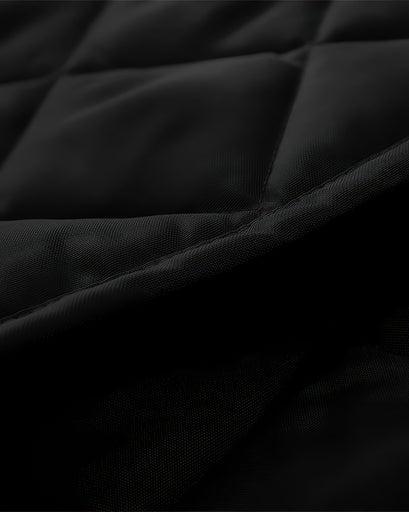 Close-up of black Oxford thermal insulated custom magnetic door curtain fabric with quilted stitching and textured PVC edge.