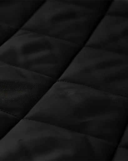 Close-up of the black Oxford custom door curtain's quilted thermal insulated and soundproof fabric, highlighting texture and stitching.