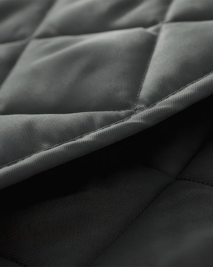 Close-up of dark grey quilted Oxford fabric on a custom thermal insulated soundproof door curtain, highlighting texture & stitching.