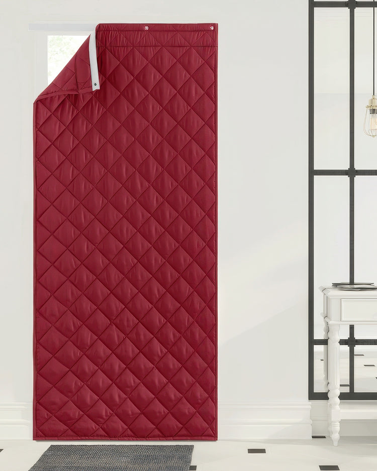 Deep red quilted Oxford custom door curtain, thermal insulated & soundproof, with grommets, partially open over a window.
