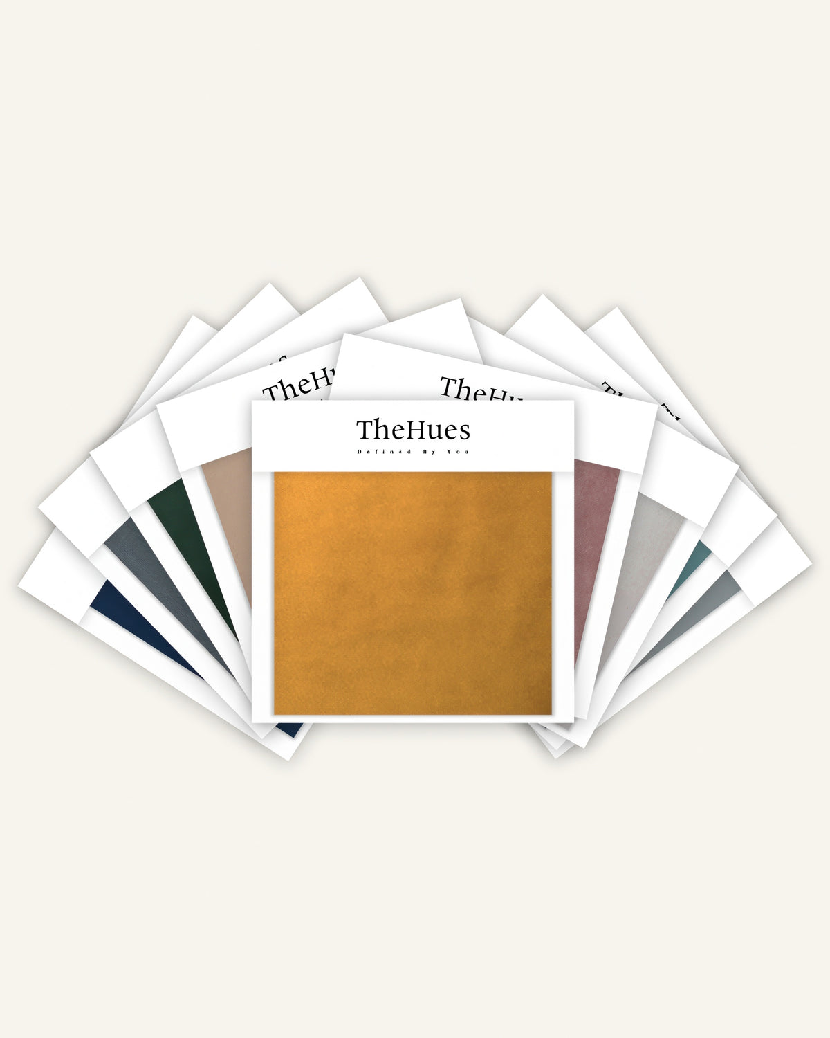 TheHues classic velvet fabric swatches fanned, showcasing luxurious golden yellow, navy, dark green, grey, dusty rose, and teal options for custom drapery.