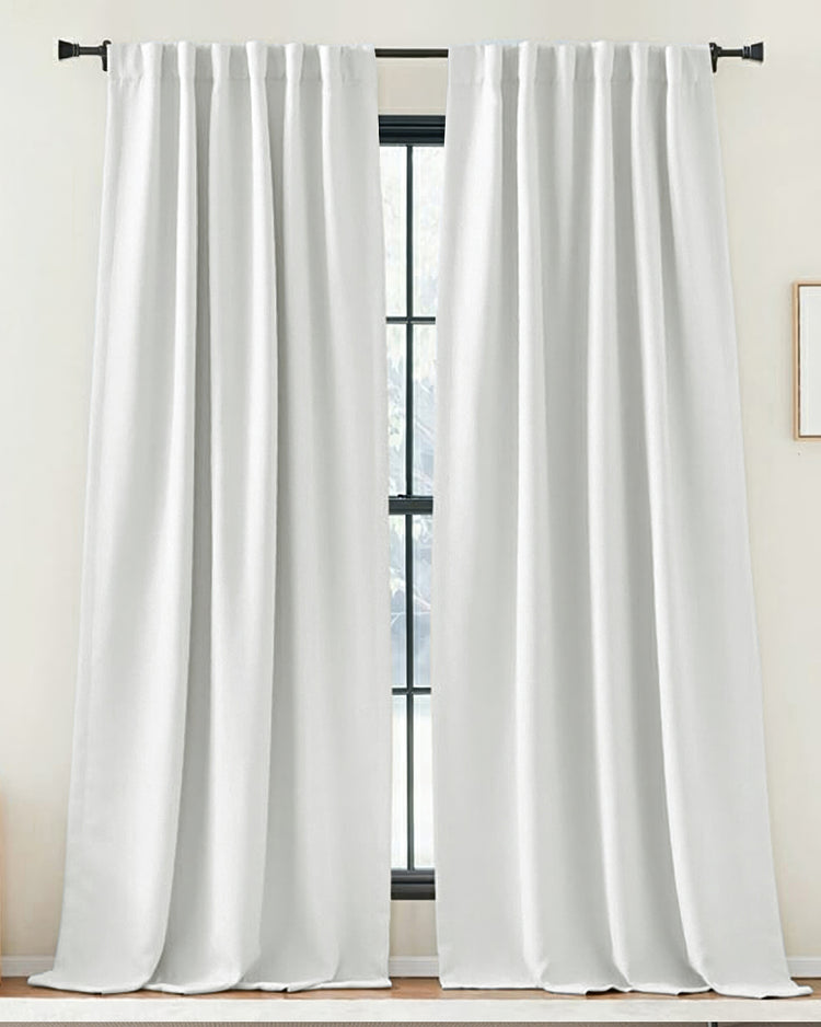 Zoe pure white linen-look custom drapery with tab top header, elegant window treatment on black rod, creating soft ambiance.